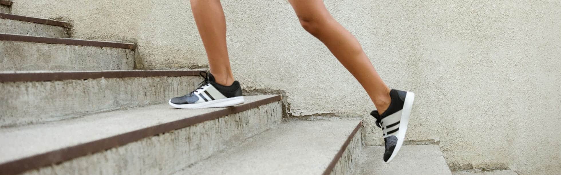 Woman running up stairs in sports shoes