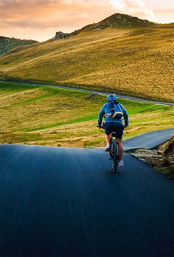 Cyclist on country road in mountains