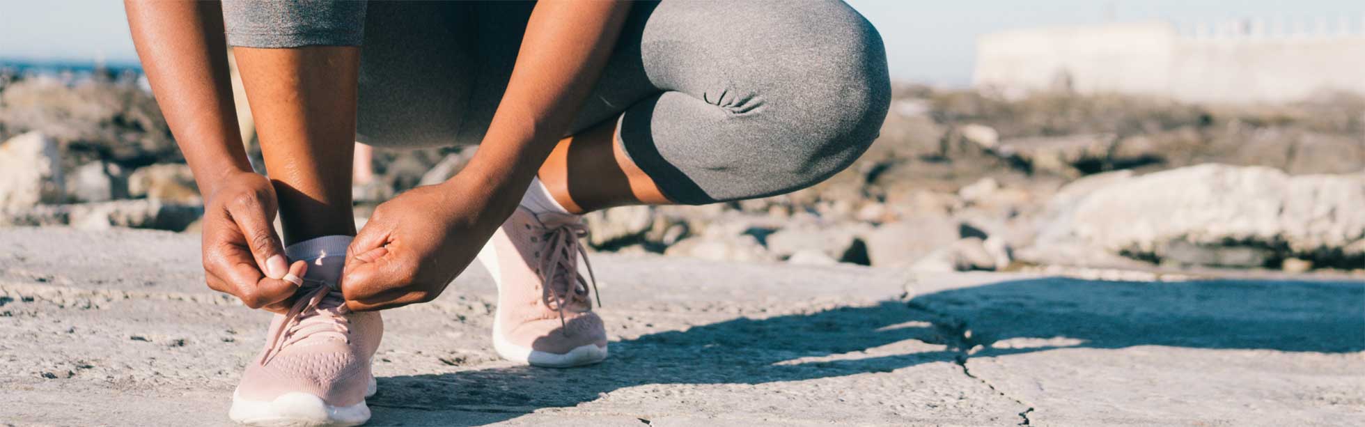 Woman tying laces on sports shoe