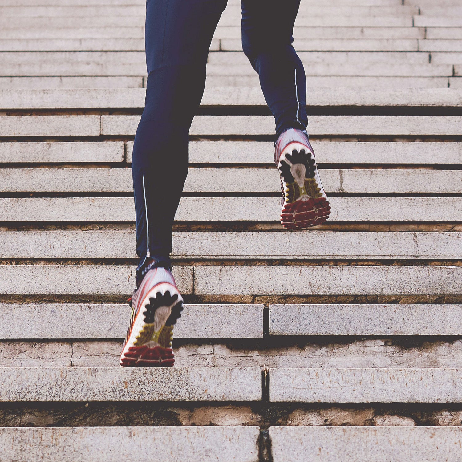 Woman running up stairs in sports clothing