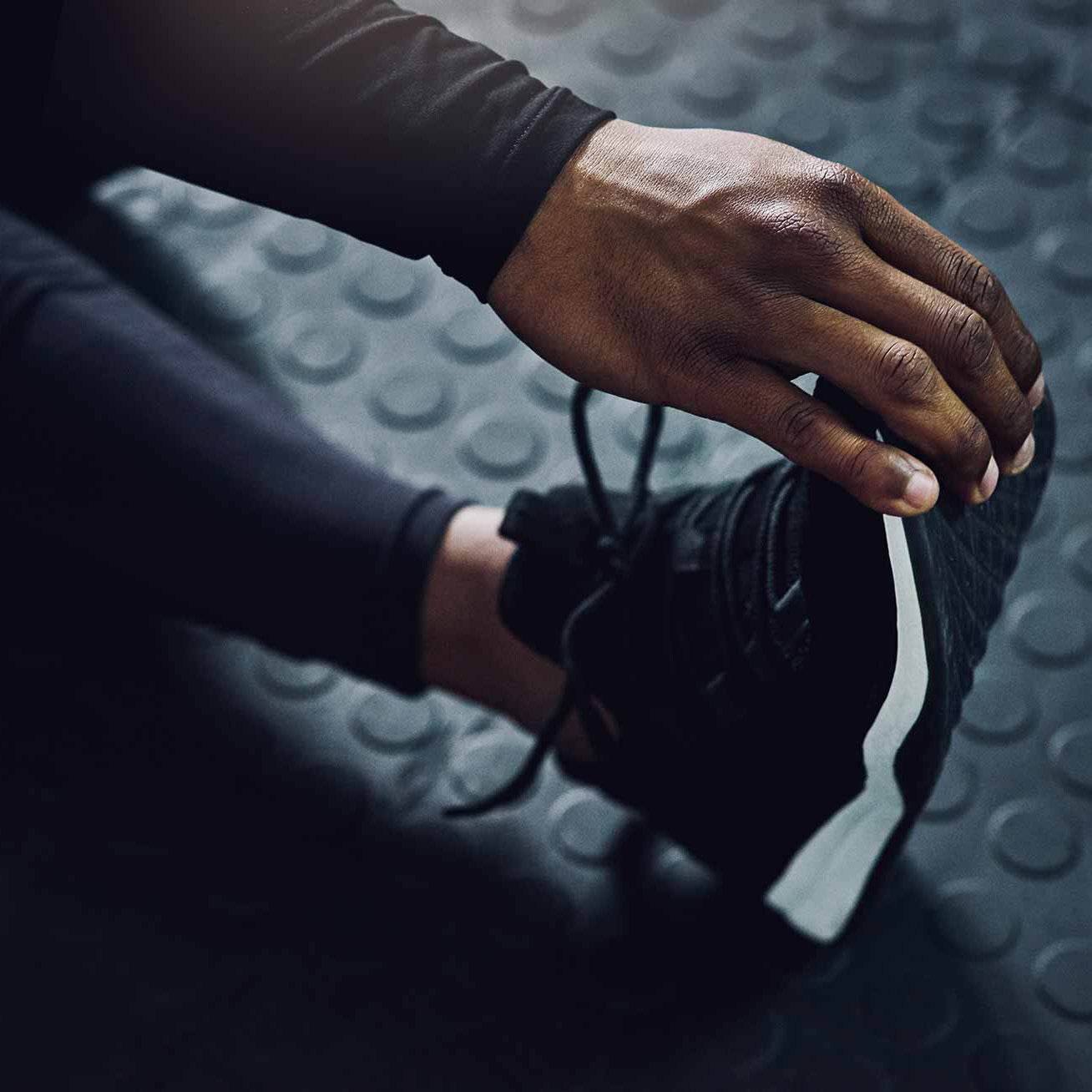 Man in sports footwear stretching leg